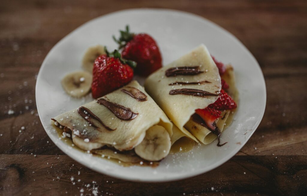 pexels-photo-3225499-3225499 Tasty French crepes topped with fresh strawberries, bananas, and Nutella sauce.
